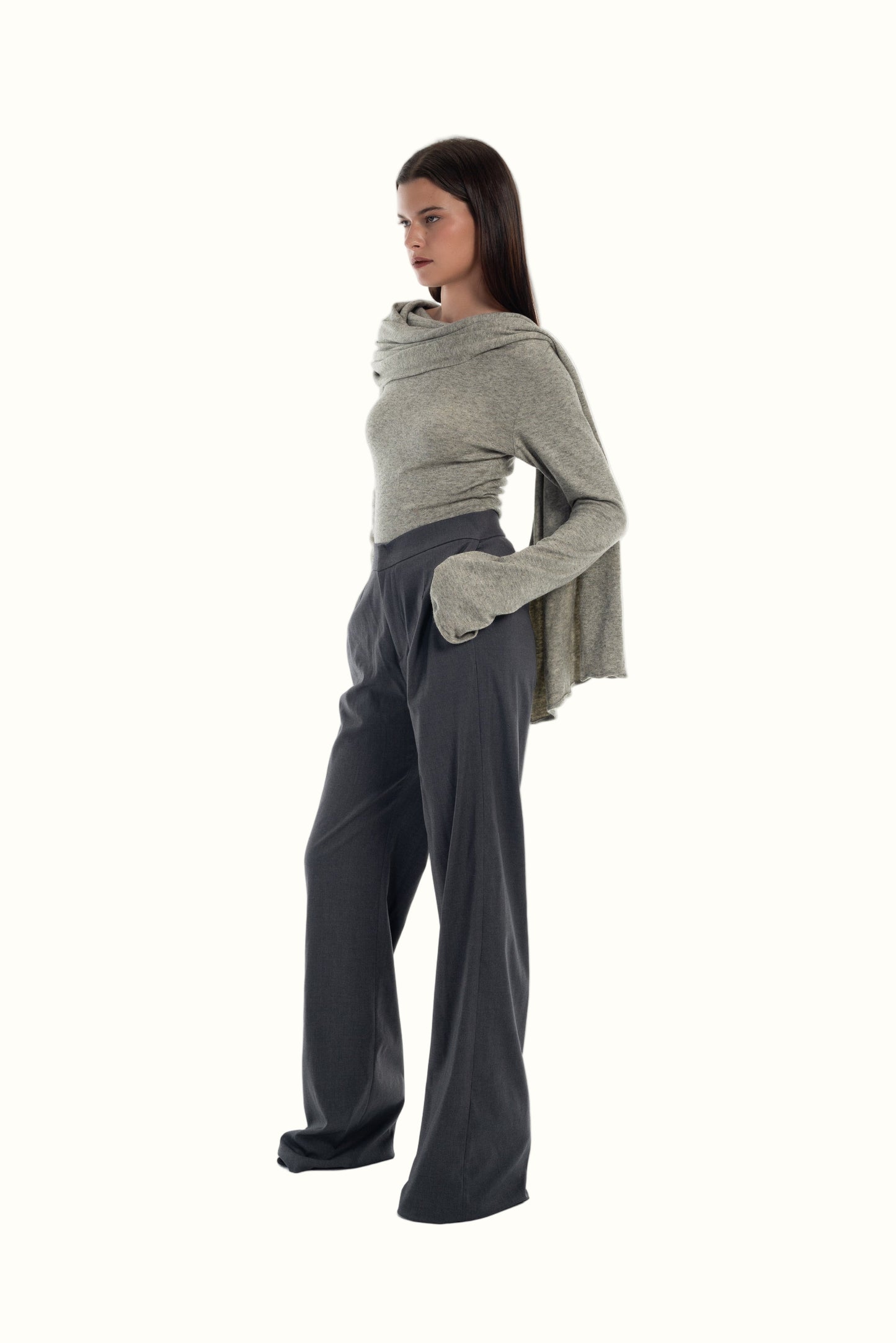 LUCE Woman wearing a gray sweater with scarf and grey pants on a white background