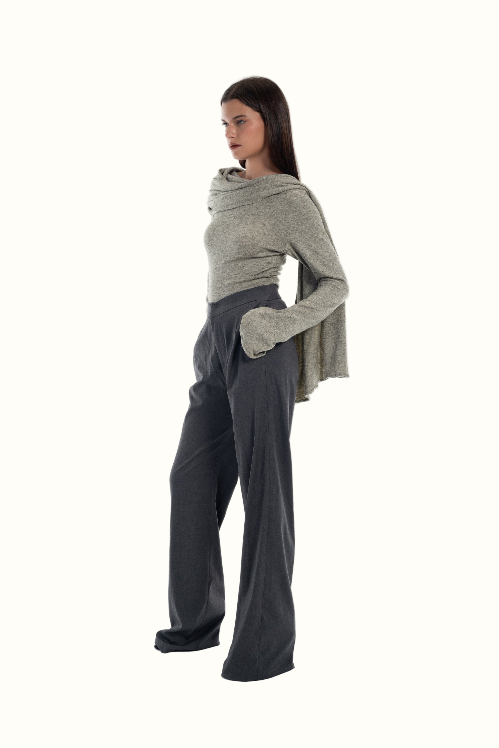LUCE Woman wearing a gray sweater with scarf and grey pants on a white background