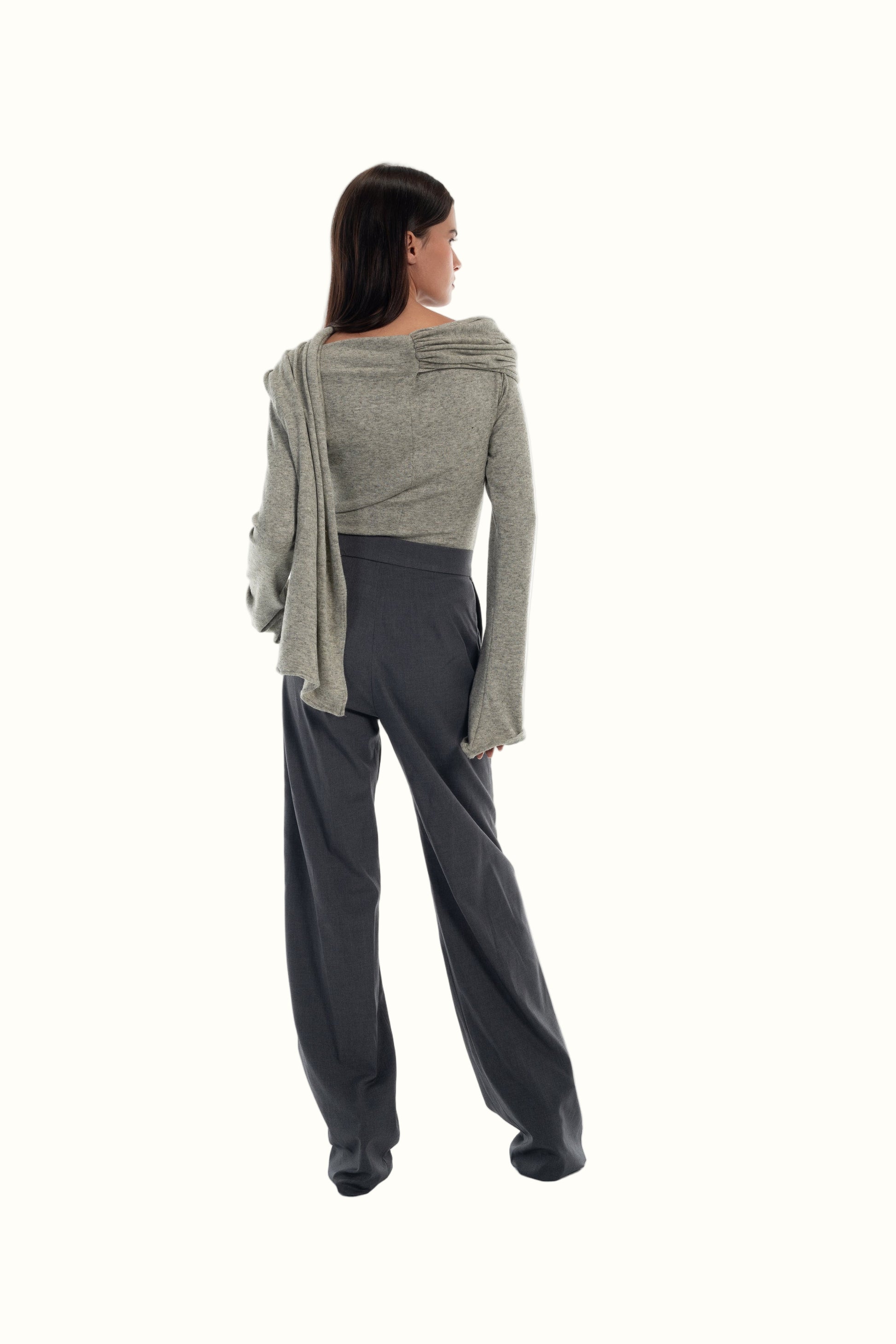 LUCE Woman wearing a gray sweater and dark gray pants on a white background