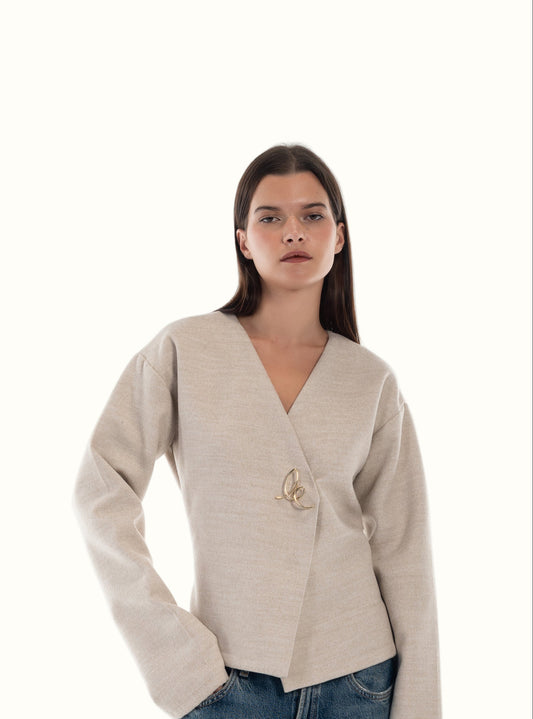 LUCE Woman wearing a beige cardigan with signature logo on a white background