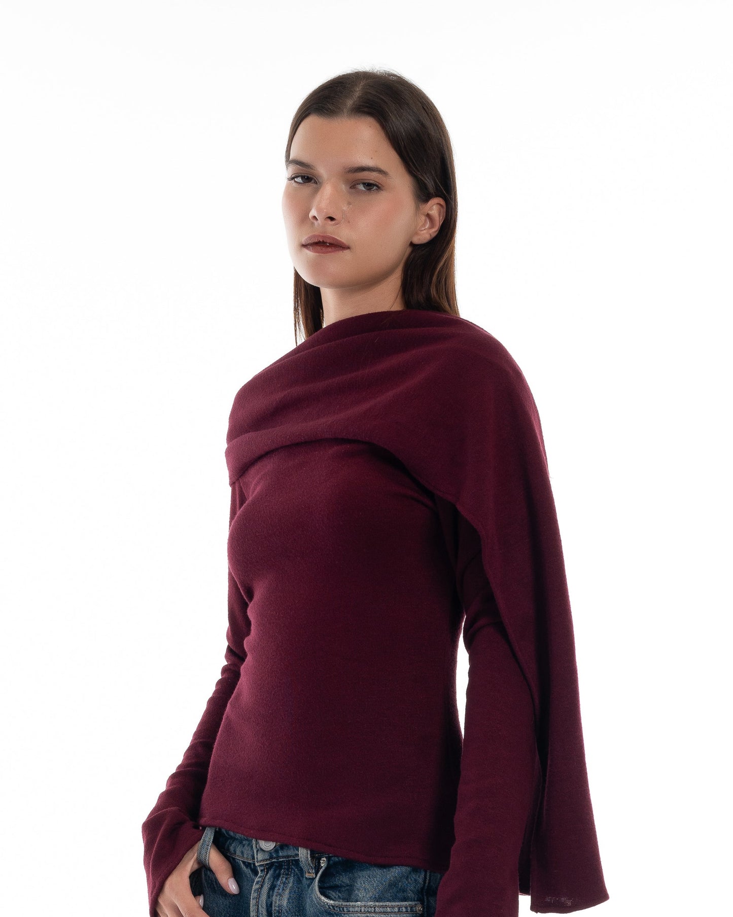 LUCE Woman wearing a burgundy sweater and blue jeans on a white background