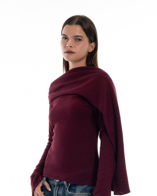 LUCE Woman wearing a burgundy sweater and blue jeans on a white background