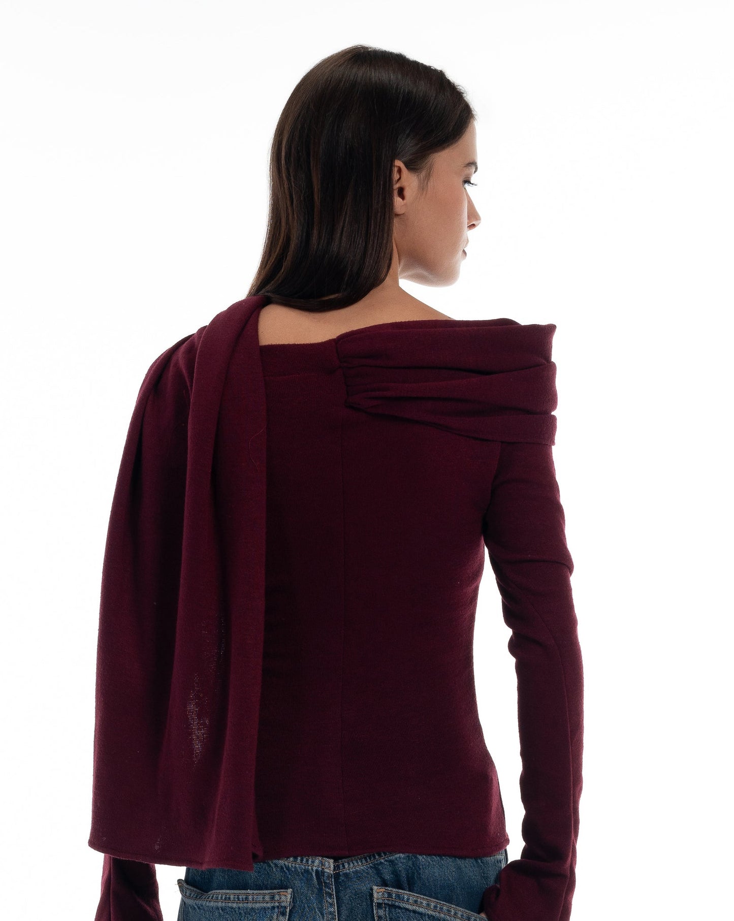 LUCE Woman wearing a burgundy off-shoulder top and blue jeans on a white background