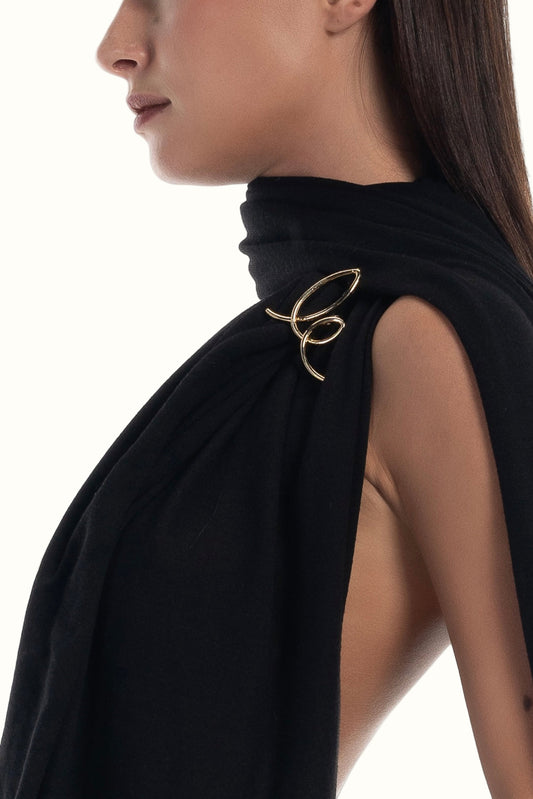 LUCE Woman wearing Long black scarf with a gold brooch logo on a white background