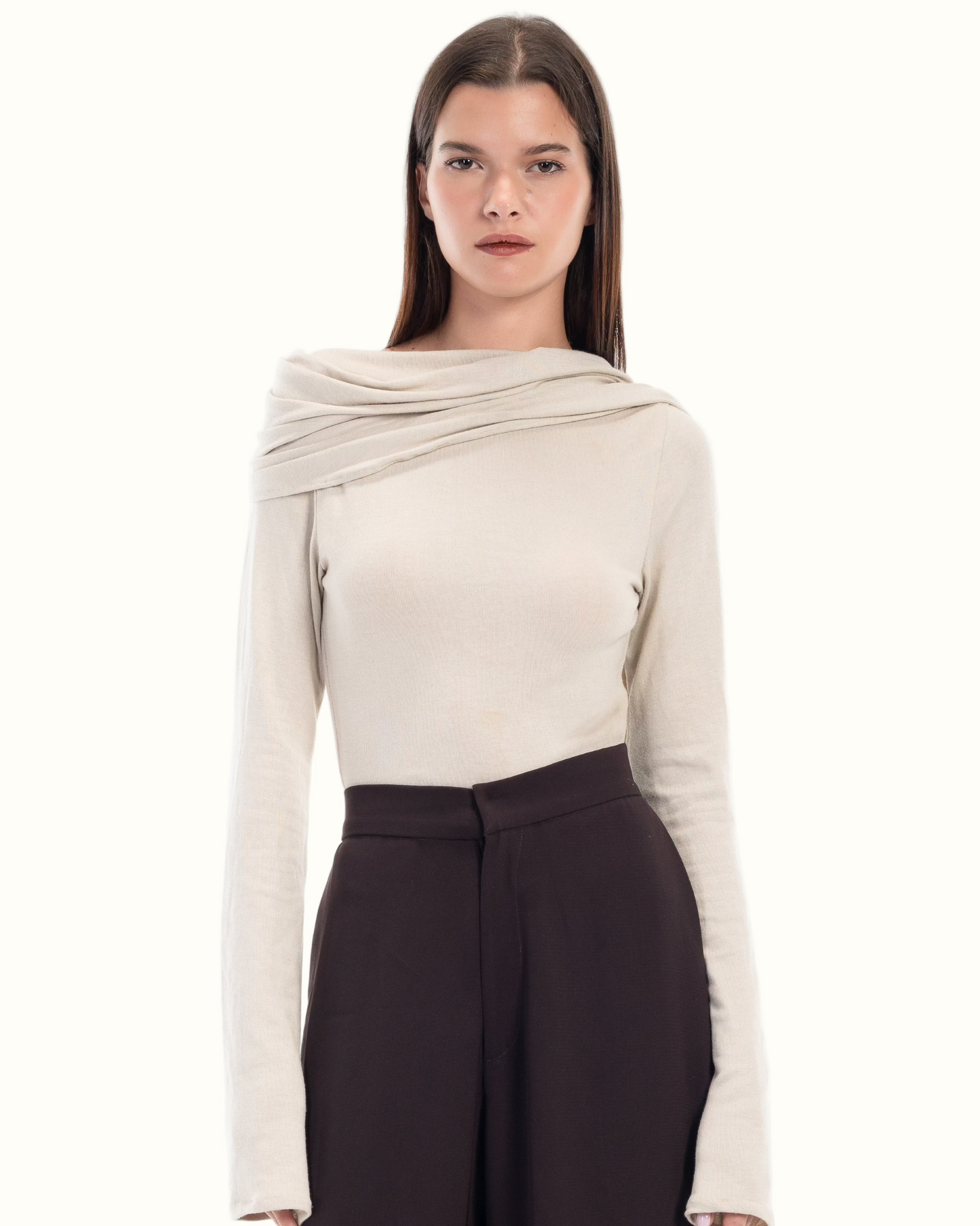 LUCE Woman wearing a beige long-sleeve cape top and dark brown pants on a white background