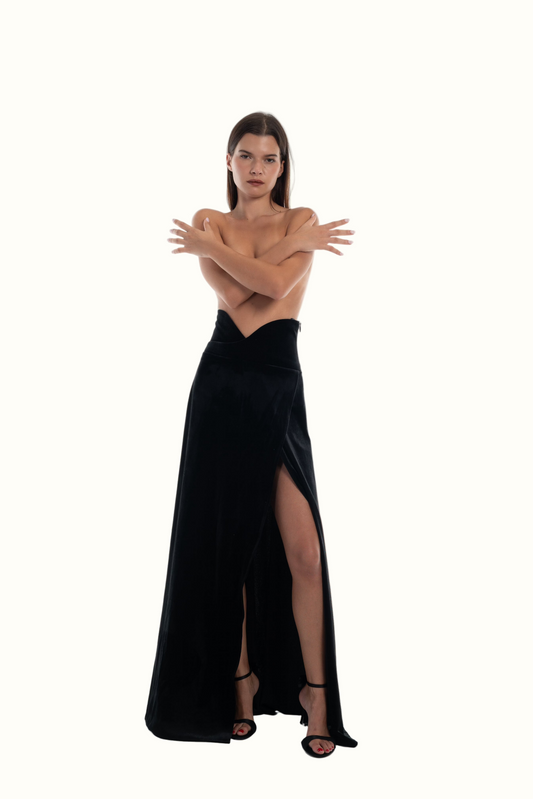 LUCE Woman wearing a black evening velvet Skirt with a slit on a white background