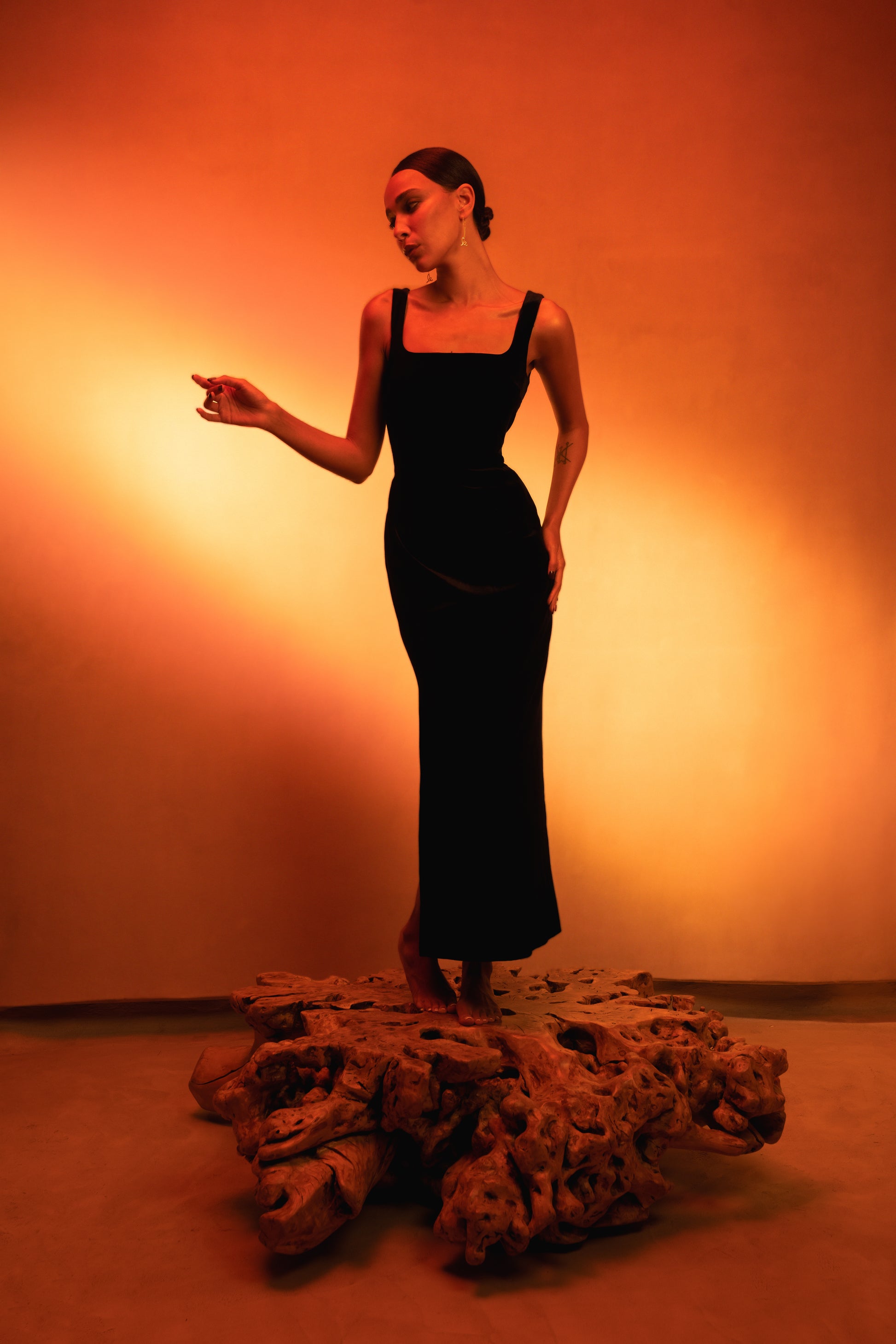 a LUCE woman wearing a black velvet maxi dress with square neckline and side slit