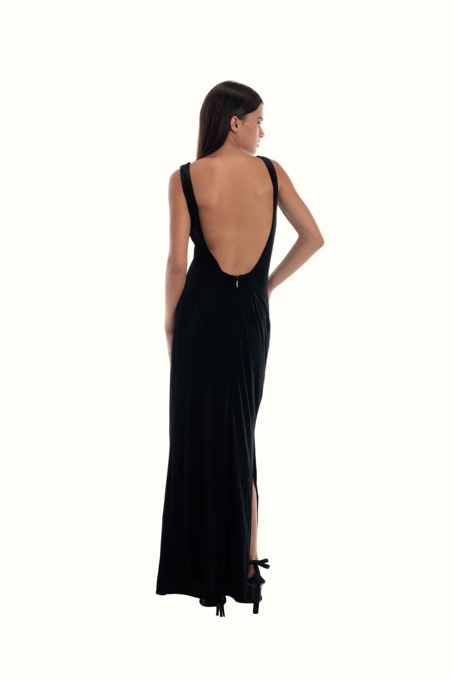 LUCE Woman wearing a black evening gown with an open back on a white background