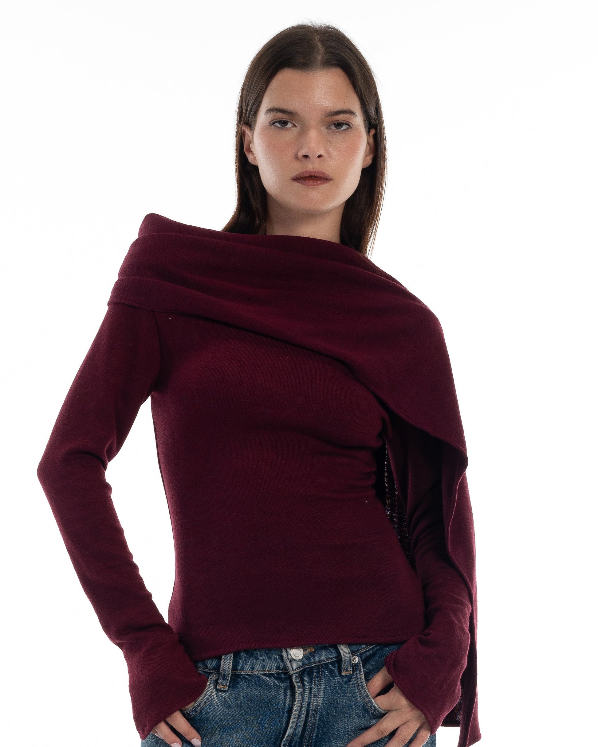 LUCE Woman wearing a burgundy sweater with a draped cape design on a white background