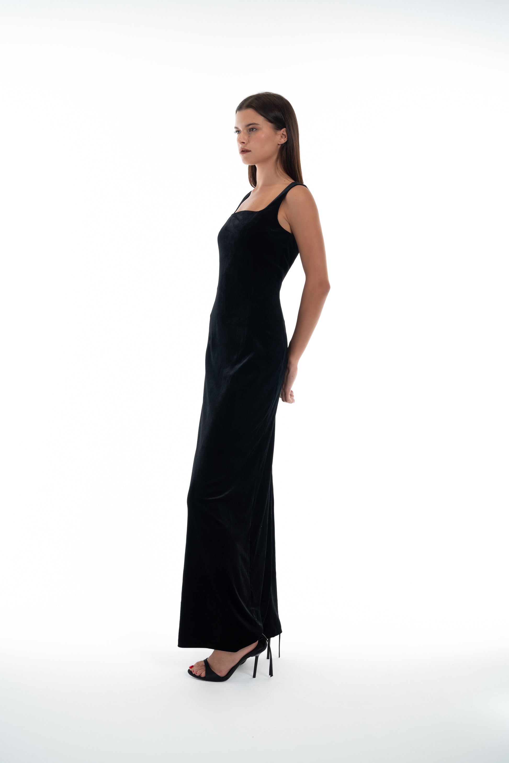 LUCE Woman wearing a black evening gown side view on a white background